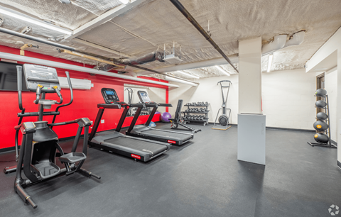 A gym with treadmills, elliptical machines, and other exercise equipment.