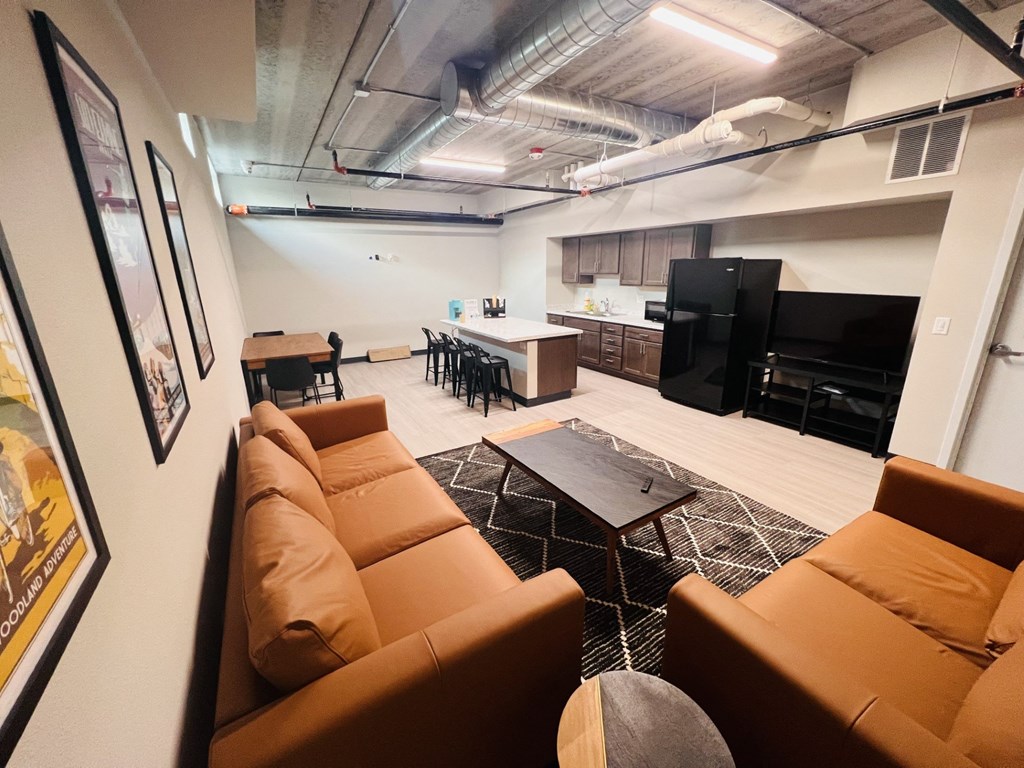 a living room with couches and a kitchen in the background