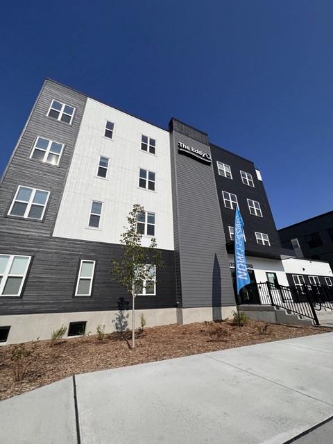 a gray and white building with a blue sky in the background
