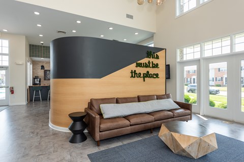 a living room with a couch and a large wall with a logo