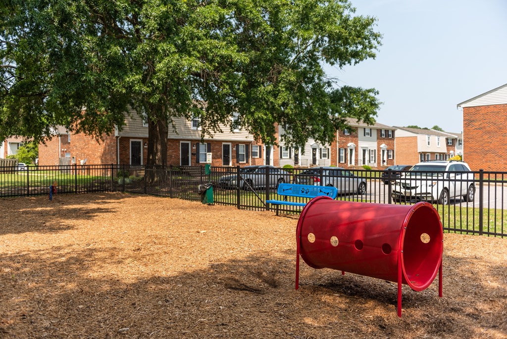 a red barrel sits in the middle of a playground
