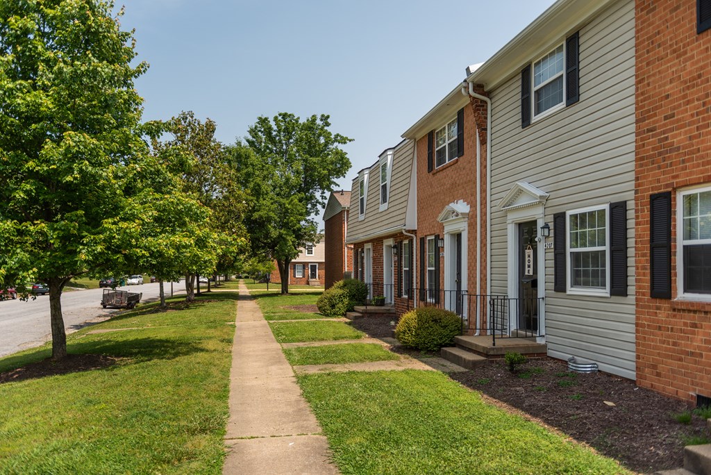 a sidewalk in front of a row of houses