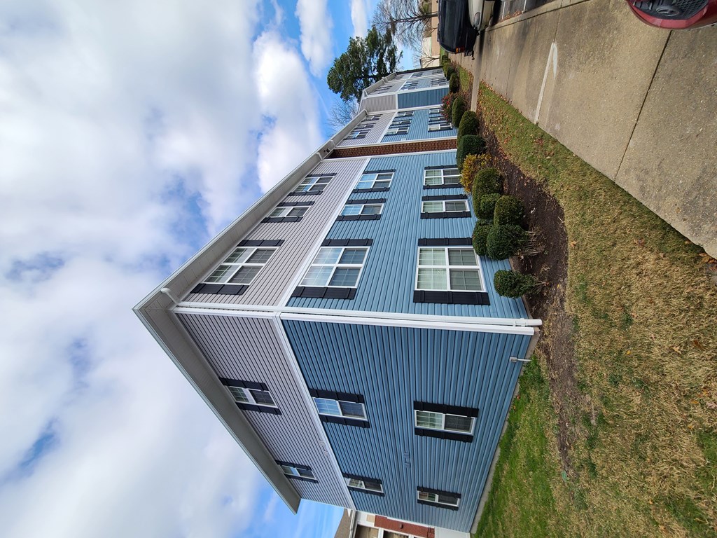 A tall blue building with white trim and windows.