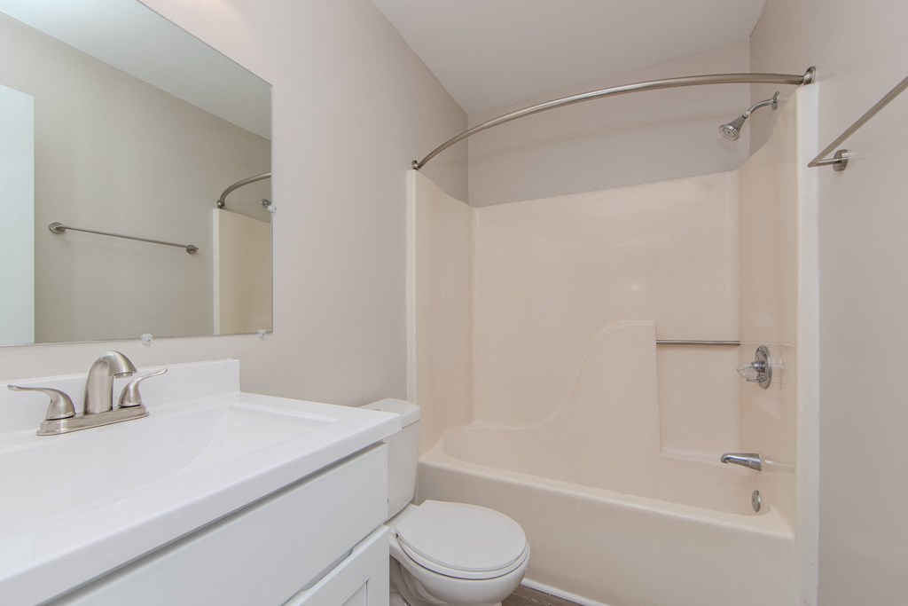 A white bathroom with a toilet, sink, and bathtub.