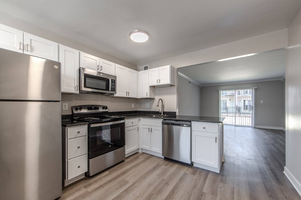 A kitchen with stainless steel appliances and white cabinets.