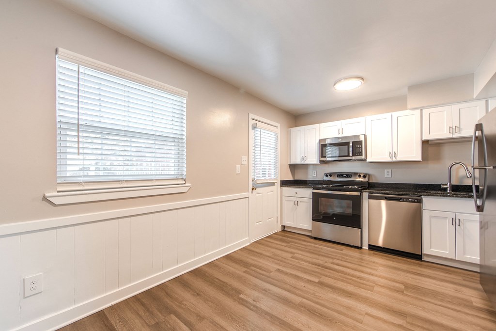 A kitchen with white cabinets and stainless steel appliances.