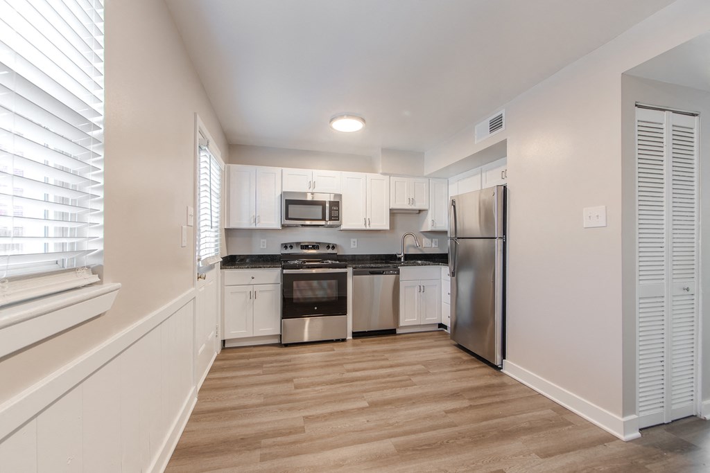 A kitchen with white cabinets and stainless steel appliances.