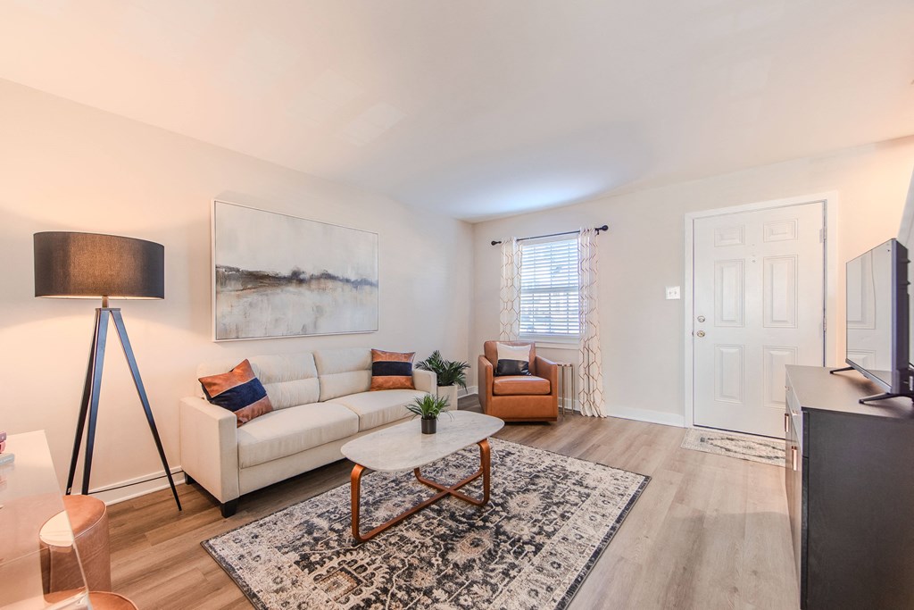 A living room with a white couch, a coffee table, and a painting on the wall.