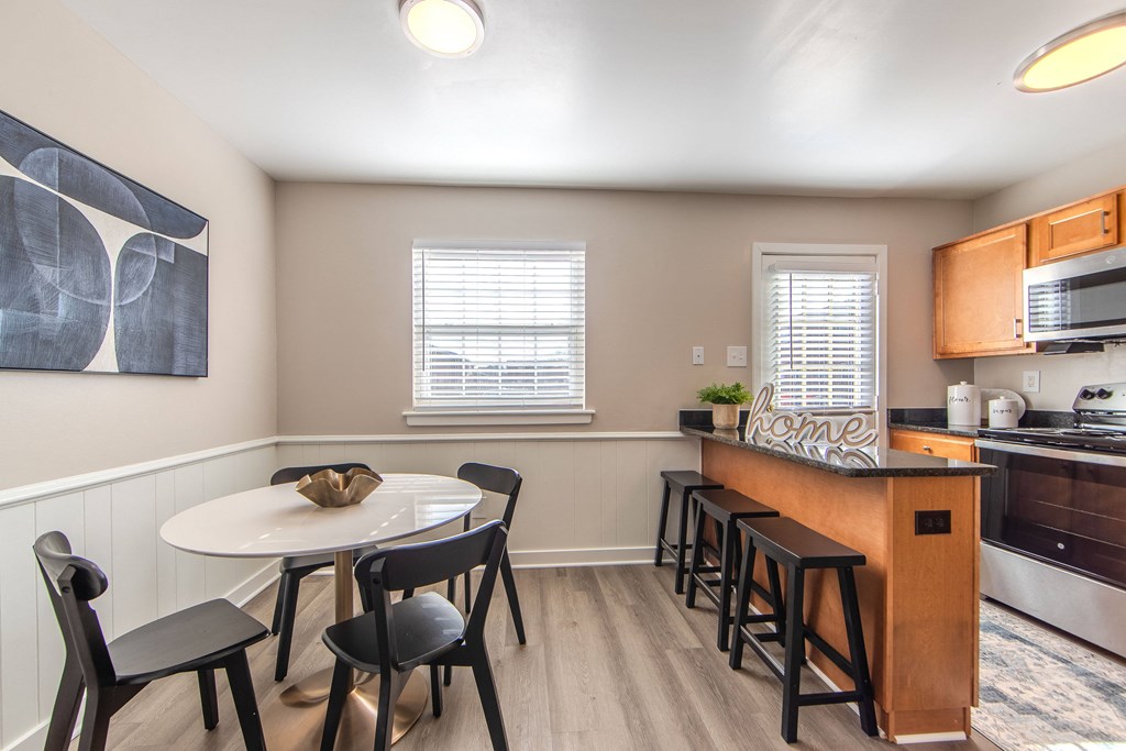 A kitchen with a table and chairs.