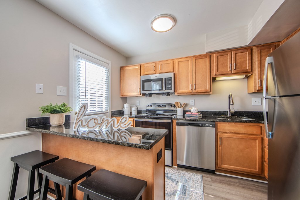 A kitchen with a refrigerator, stove, and microwave.