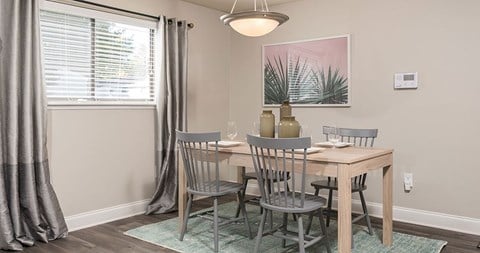 A dining room with a wooden table and grey chairs.