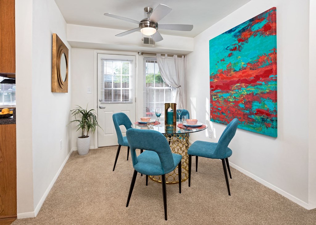 a dining room with a table and chairs and a ceiling fan