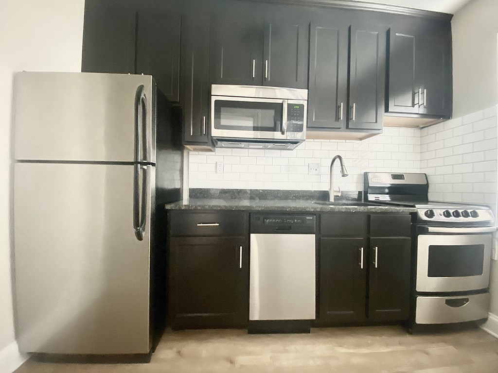 a kitchen with stainless steel appliances and black and white cabinets
