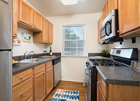 a kitchen with wood cabinets and granite counter tops and a stove top oven