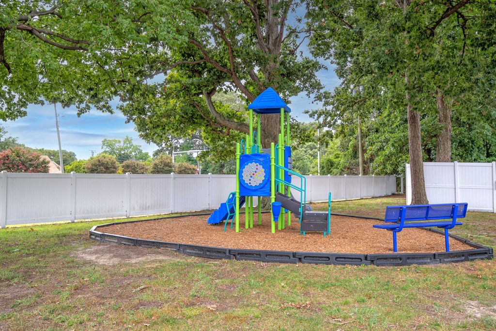 A playground with a blue slide and a blue bench.