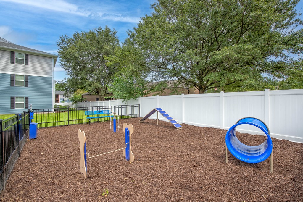 A playground with a blue slide and wooden climbing structures.