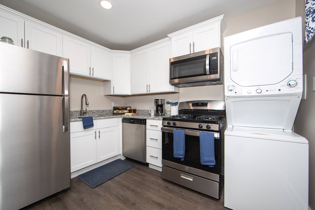 a kitchen with white cabinets and stainless steel appliances and a stainless steel refrigerator