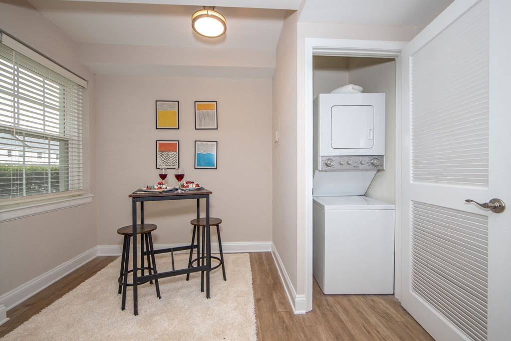 a small kitchen with a bar and a washer and dryer in a room