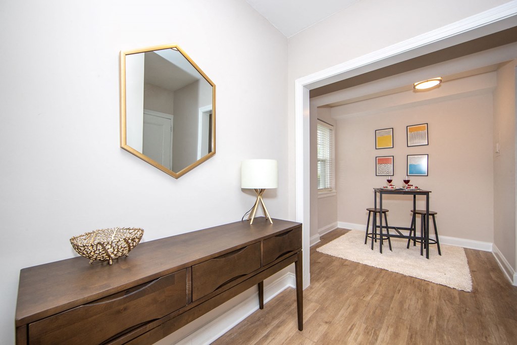 a living room with a large mirror and a wooden credenza