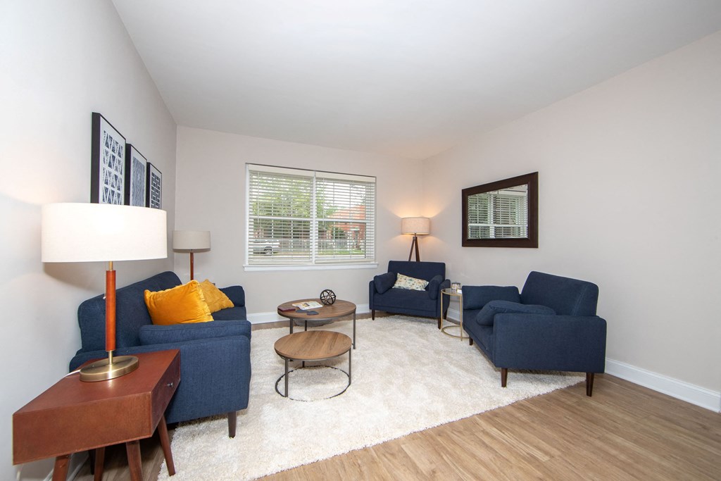 a living room with two blue couches and a coffee table and a window