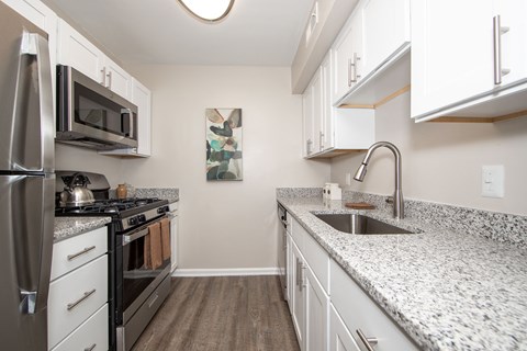 a kitchen with granite counter tops and stainless steel appliances