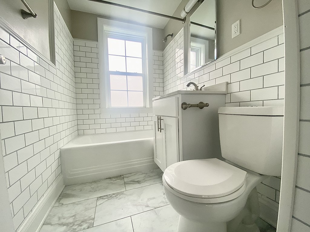 a white bathroom with a toilet and a sink