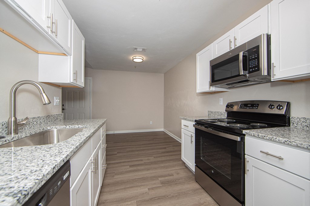 a kitchen with white cabinets and black appliances