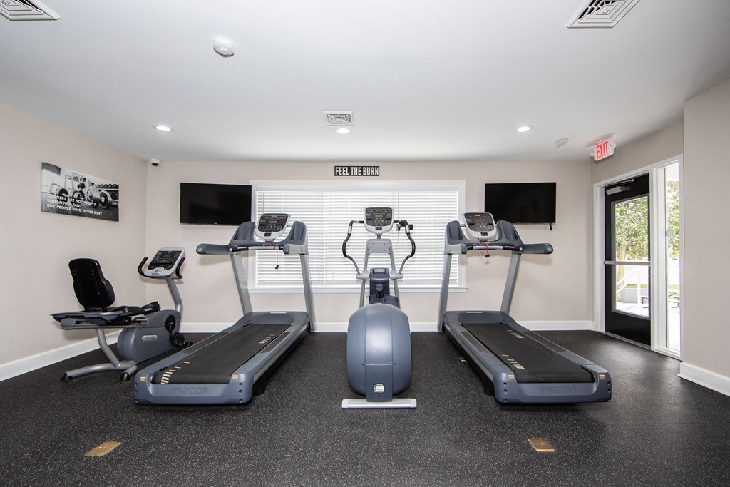 A gym room with treadmills and exercise equipment.