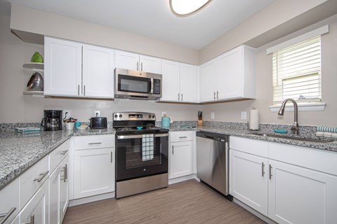 a kitchen with white cabinets and stainless steel appliances