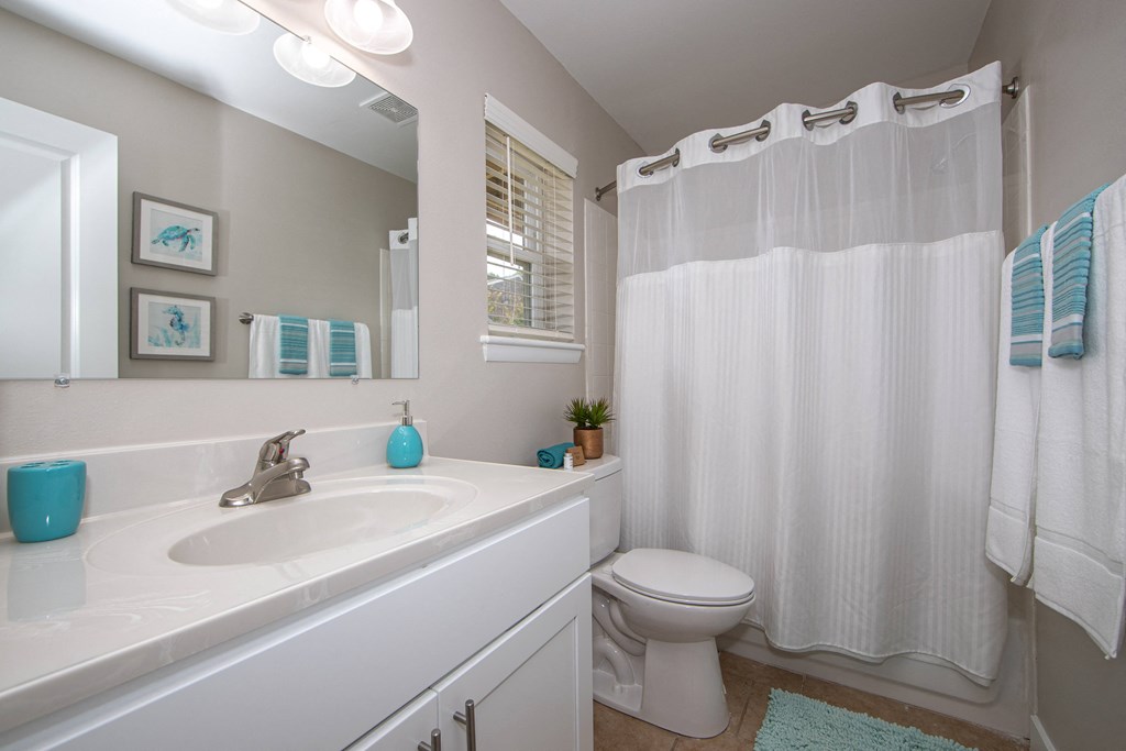 Newly remodeled bathroom with cultured marble top white vanity with storage