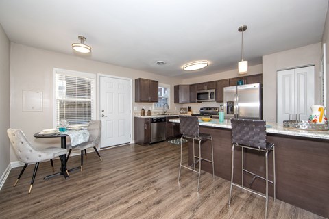 a kitchen with a breakfast bar and a dining table with chairs