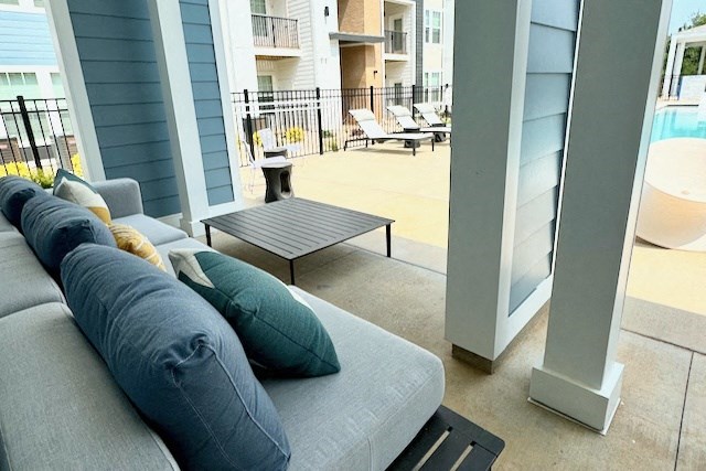 a living room with couches and a table in front of a pool