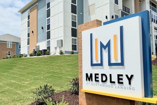 a sign in front of an apartment building