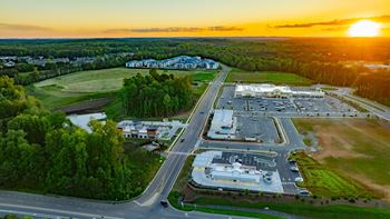 an aerial view of a parking lot and buildings at sunset