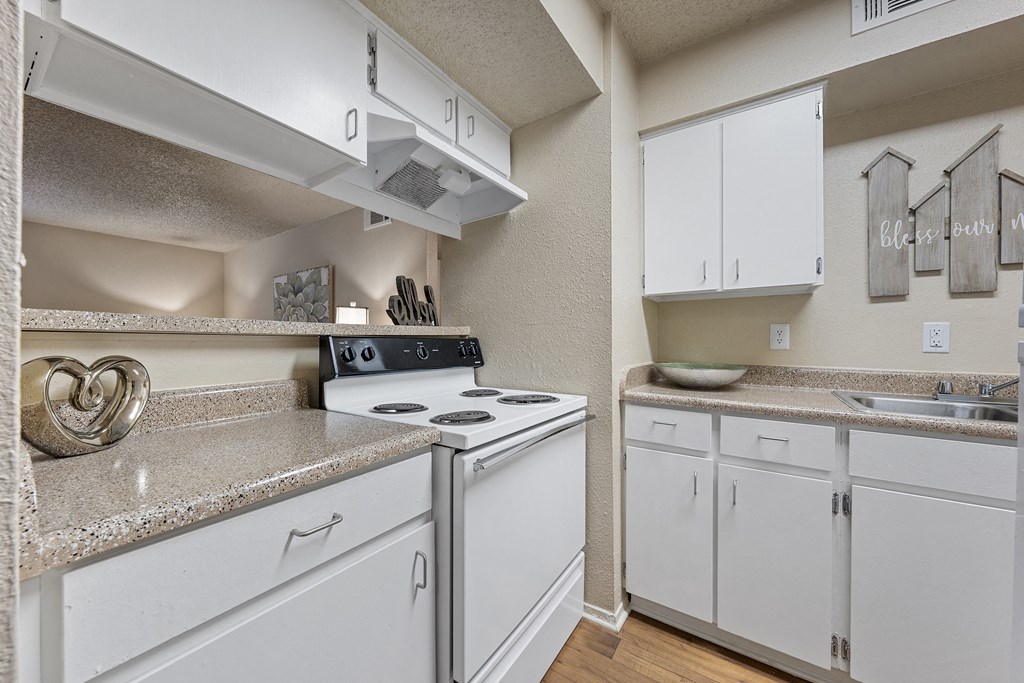 a kitchen with white appliances and granite counter tops and white cabinets at Parks on the Green, Temple, Texas