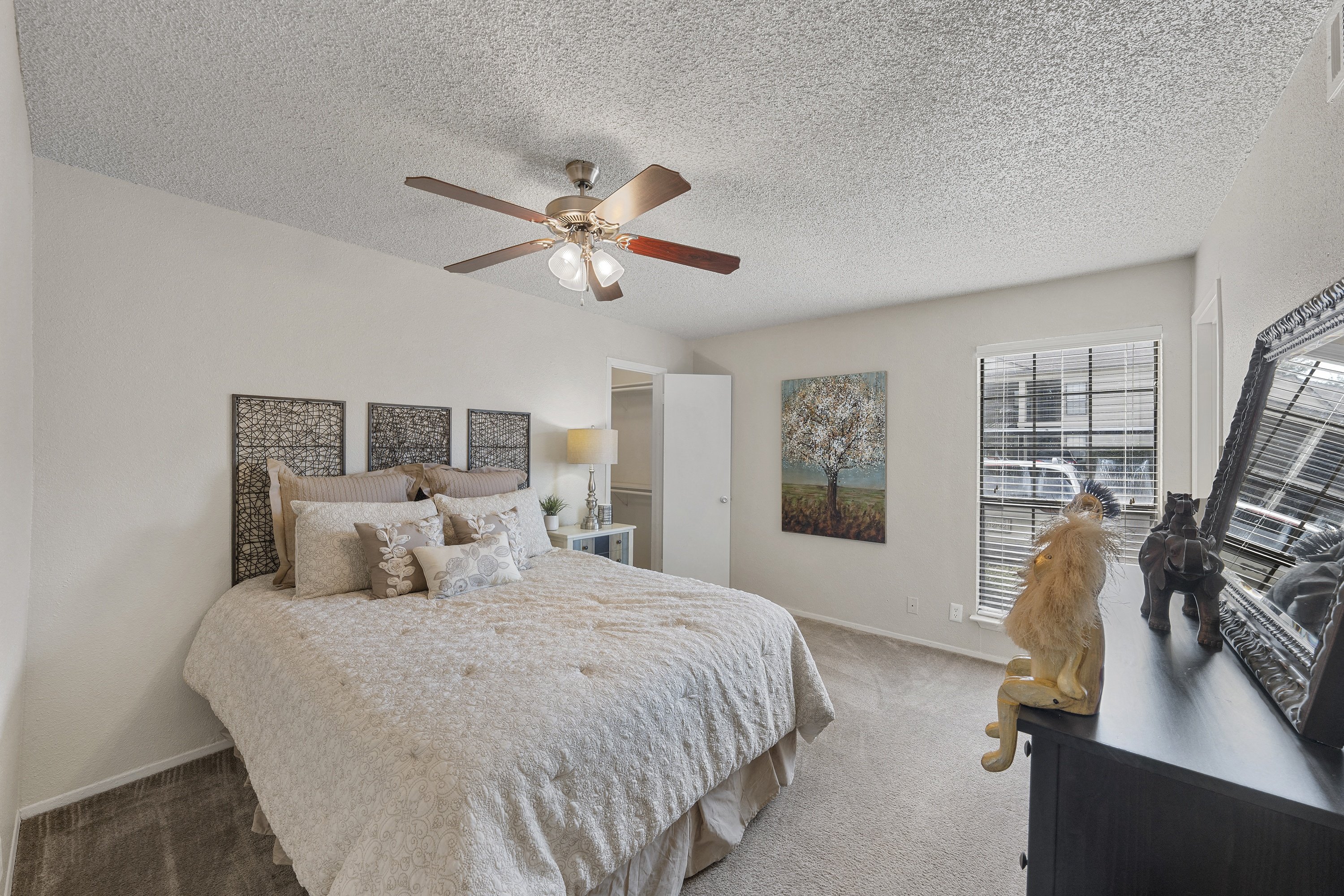 a bedroom with a large bed and a ceiling fan