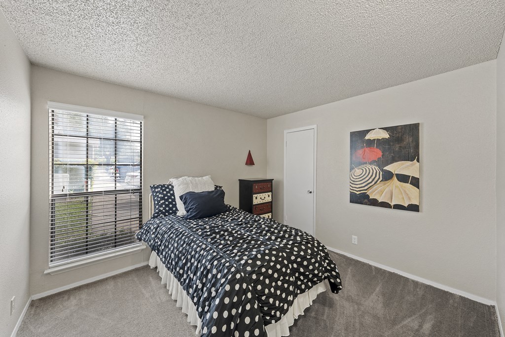 a bedroom with a bed and a large window at Parks on the Green, Temple, Texas