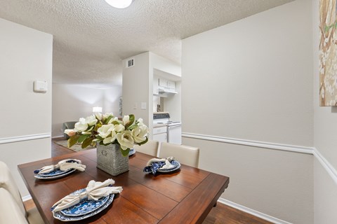 Dining room with wood table and place settings at Parks on the Green Apartments, Temple, TX 76504