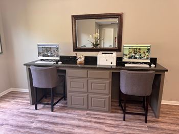 A vanity desk with a mirror and a laptop on it.