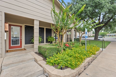 Building entrance with landscaped garden and flowers at Parks on the Green Apartments, Temple, Texas