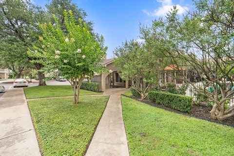 Front yard with mature trees and sidewalk at Parks on the Green Apartments, Temple, 76504
