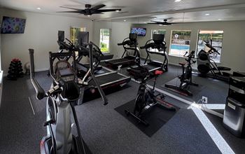 A room with a row of stationary bikes.