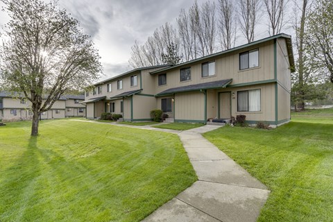 the view of a house with a sidewalk and grass