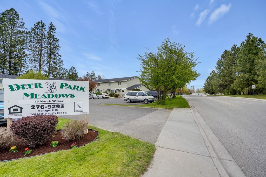 a sign for deer park meadows on the side of a street