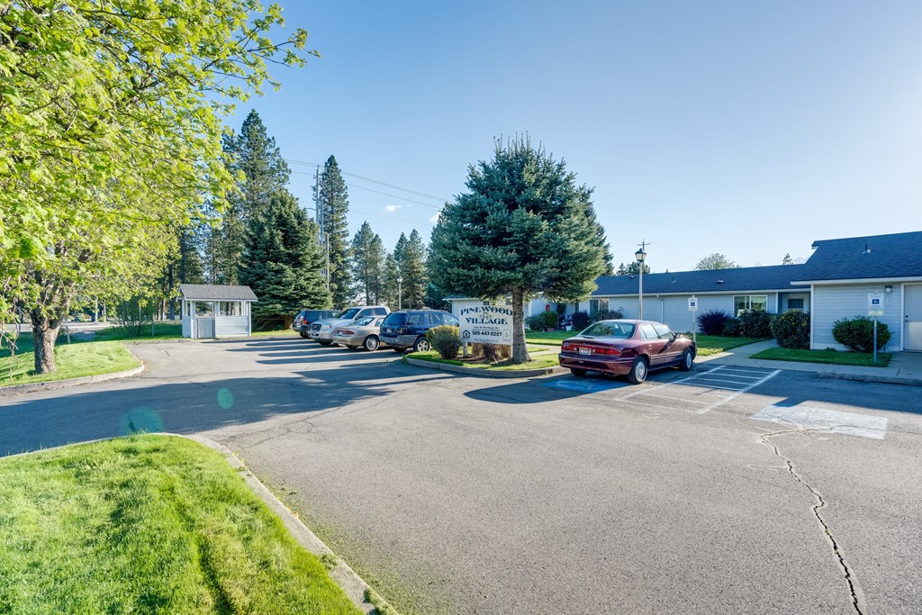 a parking lot with cars parked in front of a house