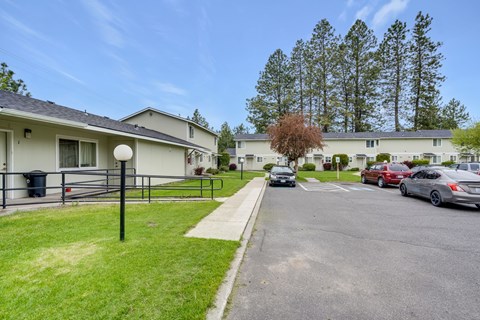 a row of houses with cars parked in a parking lot