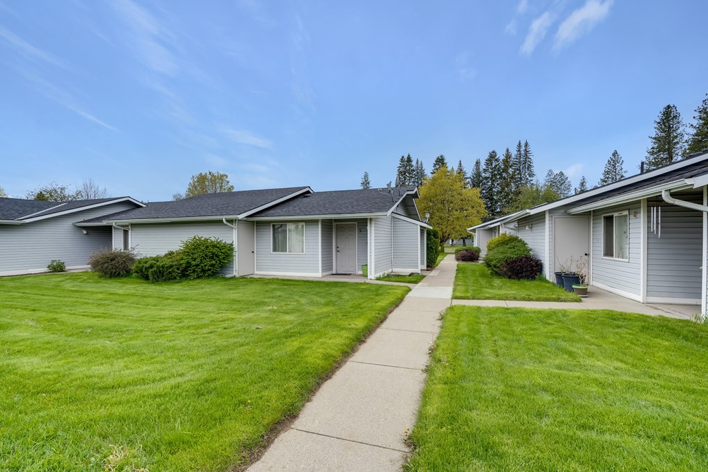 a row of white houses on the side of a sidewalk
