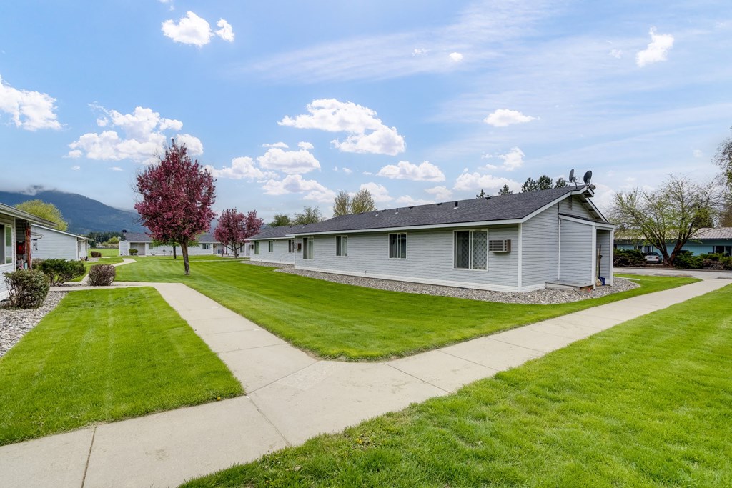 a white house with a lawn and a sidewalk