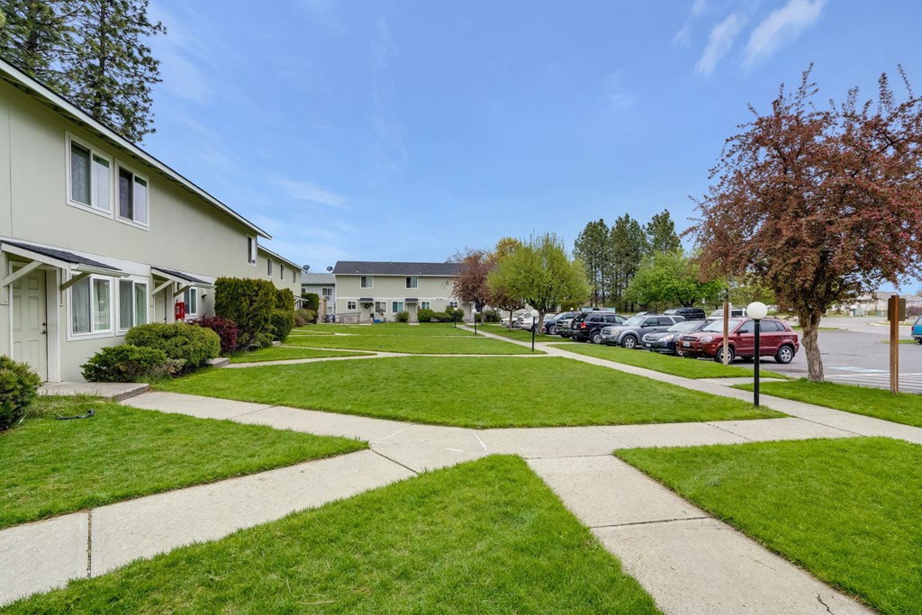 a neighborhood with houses and lawns on a sunny day