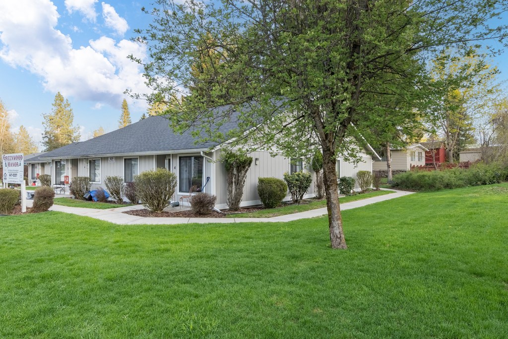a white house with a yard and a tree
